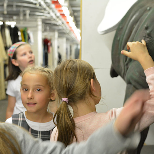 Patenkinder einer Produktion für junges Publikum entdecken den Kostümfundus der Deutschen Oper am Rhein. FOTO: Krysztina Winkel